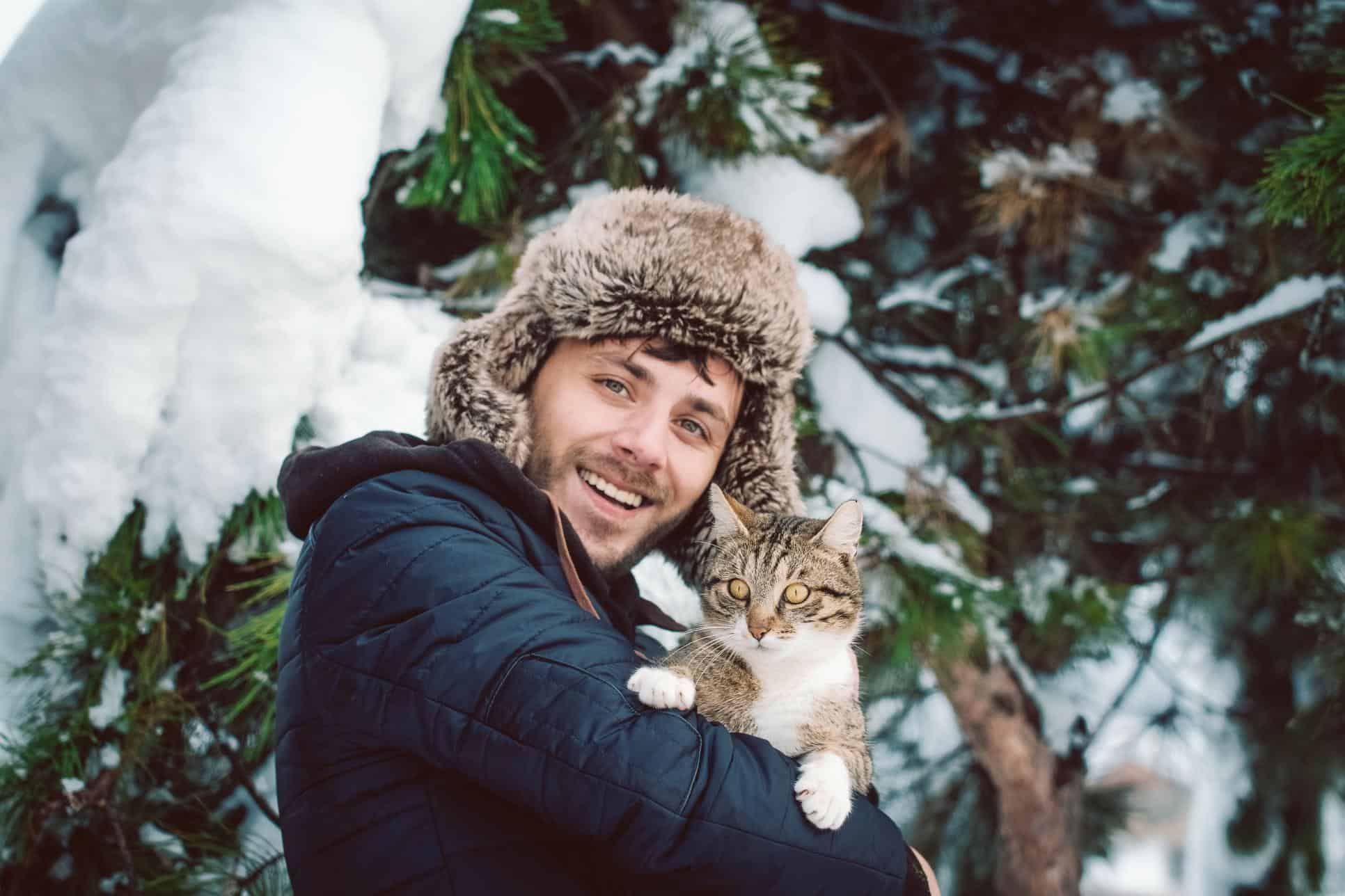 man holding outdoor cat.